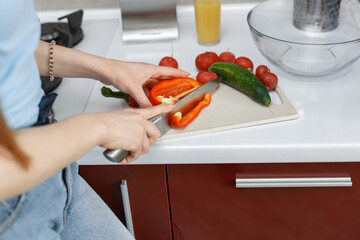 Beautiful girl make a salad. Woman in a kitchen/ Lady in a blue t-shirt