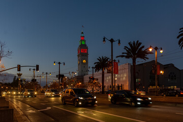 Fototapeta na wymiar SAN FRANCISCO USA - DECEMBER 8 2019; The Ferry building at the end of the street illuminated at night
