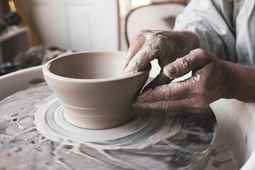 Fototapeta na wymiar Woman's Hands Shaping Clay into Bowl on Pottery Wheel