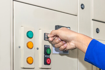 Naklejka premium Hand of people key switch select mode in electrical control panel contains switch buttons for operating industrial machine and factory equipment in industry