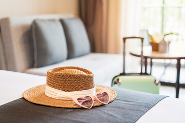 Hat and sunglasses with luggage in hotel room, Travel concept