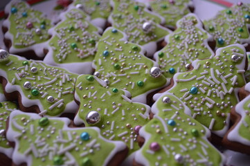 Christmas ginger cookies at green tree and many candy for background