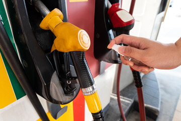 Person spray sanitizer onto fuel gas pump before using as protection against germs
