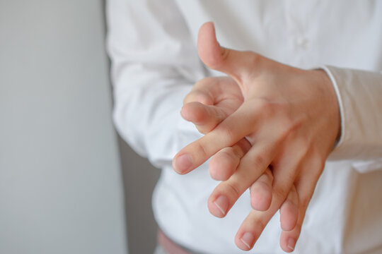 Young man is rubbing his hands with hydro alcoholic gel, in order to prevent infection of COVID-19