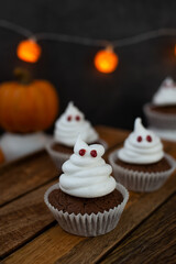 Halloween ghost cupcakes , homemade sweet chocolate muffins with meringue ghost