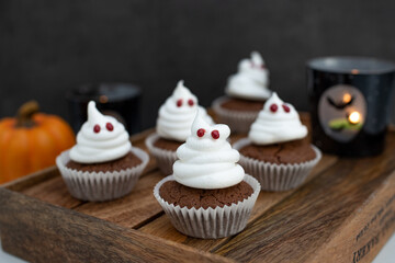 Halloween ghost cupcakes , homemade sweet chocolate muffins with meringue ghost