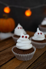 Halloween ghost cupcakes , homemade sweet chocolate muffins with meringue ghost