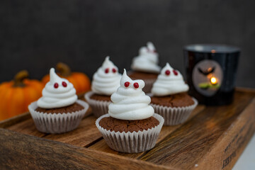 Halloween ghost cupcakes , homemade sweet chocolate muffins with meringue ghost