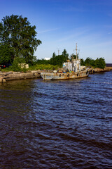 Naklejka premium The city of Kronstadt. Russia. June 12, 2019. A rusty ship is moored in the port. The middle of the harbor. Urban landscape.