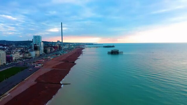 Brighton Seafront an aerial video along the historic coastline of this south coast resort, with the sun rising over a calm sea.