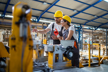 Industrial employees working together in factory production line.