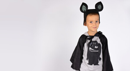 Bat boy in carnival costume, a nice character. Serious boy against the white background with side empty space . Happy Halloween.