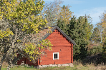 Fototapeta na wymiar Beautiful red wooden farmhouse. House painted in traditional Swedish color.