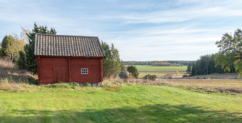 Obraz premium Beautiful red wooden farmhouse. House painted in traditional Swedish color.