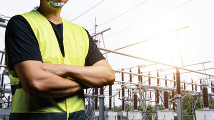 An electrician wearing a black t-shirt and a reflective vest. To prepare for the maintenance of...