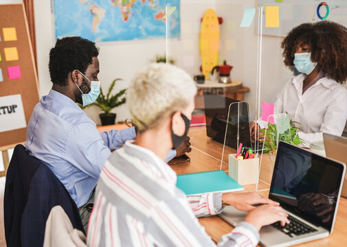 Multiracial people working in coworking office with safety measures for coronavirus - Business and technology
