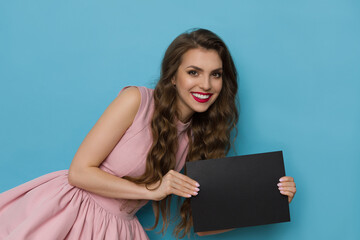 Happy Young Woman In Elegant Pink Cocktail Dress Is Holding Black Card