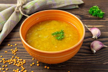 Red lentil soup on wooden background. Traditional Indian spicy soup. Vegan and vegetaria food.