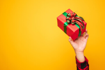 Young man holding the box celebrate with his birthday on yellow background. Merry christmas and Happy new year 2021 male hands holding the present gift box.
