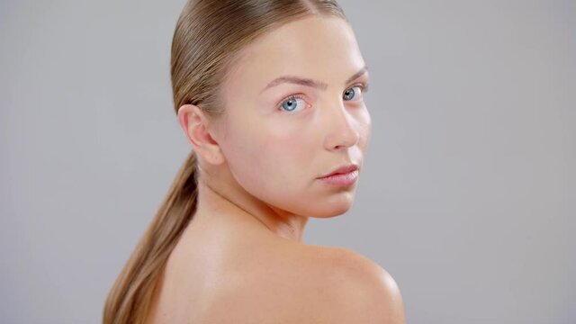 Close Up Beautiful Young Caucasian Blonde Woman With Blue Eyes And Smooth Healthy Skin Touches His Face With Hand Skin Care Cosmetic Concept Slow Motion On Grey Background
