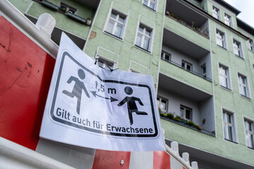 Hinweisschild zum Abstand halten nahe einer Berliner Schule