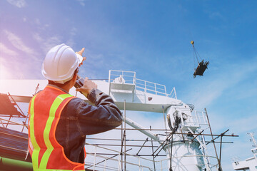 shipyard repairing and crane during installed scaffolding in floating  walkie- talkie or portable radio transceiver for communication in hand holding control worker order for maintenance 