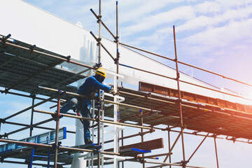 Workers on high install scaffolding, stage on board in shipyard during ship Maintenance and Repair wearing safety harness for safety concept on blue sky background.
