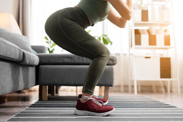 Close up fitness woman squatting exercise at home