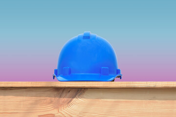Blue Safety helmet hard hat on wooden for safety first concept on blue background.