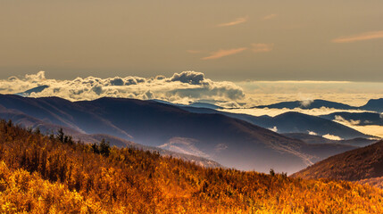 The low-set clouds surrounding the mountain peaks create the illusion of sea waves crashing against islands.