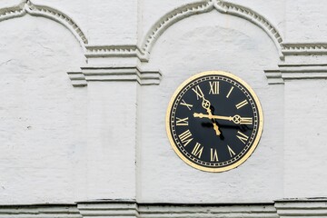 Russia, Yaroslavl, July 2020. Classic style clock on the white wall of the monastery.