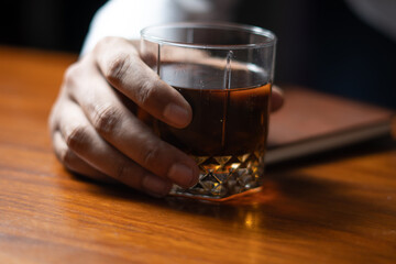 holding beverage drink in hand on table with dark moody lighting