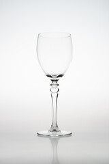 High key studio image of a wine glass with a white background. The silhouette of the glass is lightning up due to flash light
