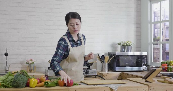 slow motion of asian woman recording video food vlog about healthy cooking in modern kitchen at home.