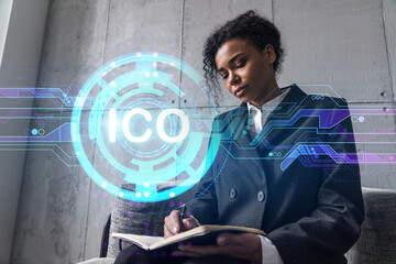Businesswoman taking notes and ICO hologram. Double exposure. Business technology initial coin...