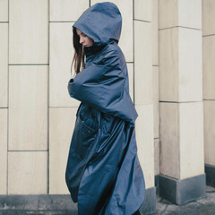Girl on the street in a raincoat, autumn weather