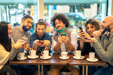 Two man looking in phone over the shoulder of girl friend and trying to see what is on the screen, in the cafe shop