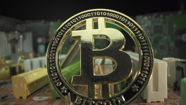 Gold coin BITCOIN btc on the motherboard in macro shot with Processor and many HDD Hard Drive Disk. Blockchain technology. Mining. Halving Bit Coin