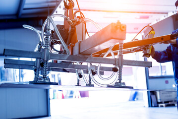 Worker uses suction cups for transporting large sheets of metal