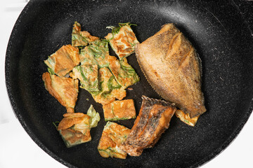 deep fried fish and Fried Egg with Climbing Wattle in the pan
