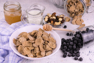 A bowl of cereals with honey, nuts and berries. The concept of quick and healthy breakfast.