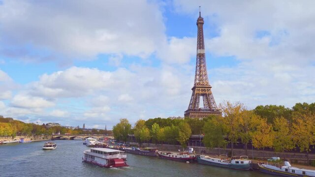 4K vedio of amazing view of the Eiffel tower from Bir-Hakeim bridge, over the river Seine , Paris, France. Paddle steamer and glass boats on river at a cloudy but sunny autumn day.