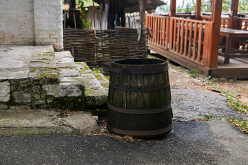 antique wooden water barrel stands by the porch