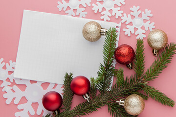 New year concept. Goals list in notepad, gift box and christmas decoration on pink pastel color with copy space