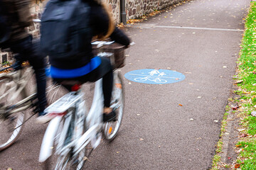 zwei Radfahrer fahren nebeneinander auf einem kombinierten Fußgänger-/ Fahrradweg,...