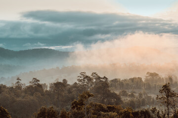 Morning atmosphere where the sun shines through the fog on the top of the hill that are arranged alternately into layers