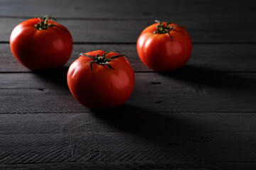 Ripe tomatoes on black background
