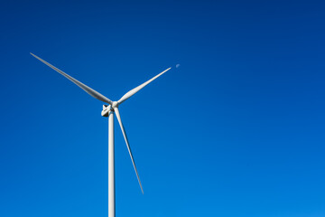 Wind turbines on a beautiful blue sky in a mountain wind farm in Sardinia. Renewable energy concept, green energy generation. Energy industry.
