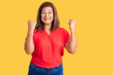 Middle age latin woman wearing casual clothes screaming proud, celebrating victory and success very excited with raised arms