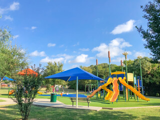 Residential area playground with sun shade sails and artificial grass in Flower Mound, Texas, USA